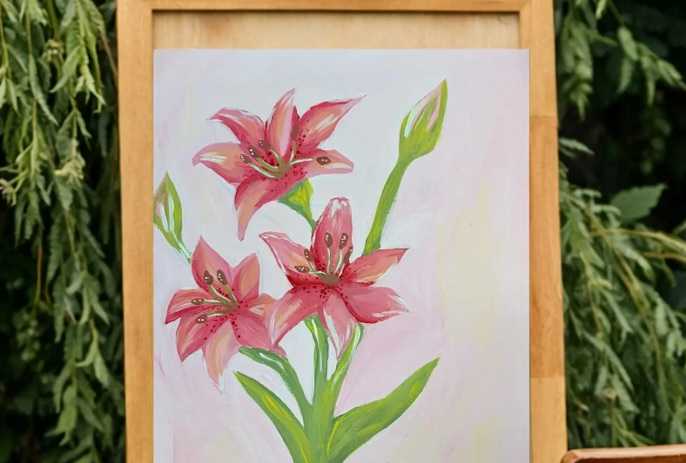 Watercolor-style painting of pink lilies on a wooden easel outdoors, surrounded by green foliage, evoking a Mother's Day art activity.