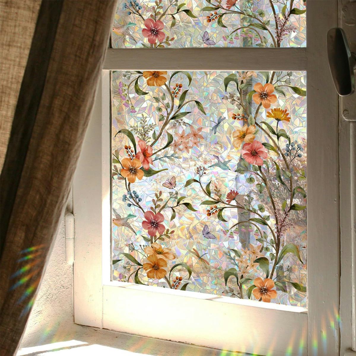 Floral stained glass privacy window film on a sunlit window with mosaic texture, colorful flowers, leaves, butterflies, and a curtain.