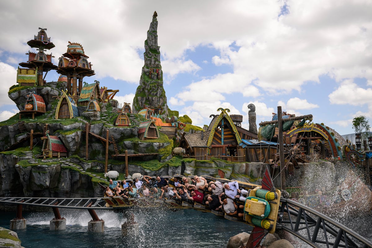 Riders splash through Universal Epic Universe's Isle of Berk on a How to Train Your Dragon family coaster beside Viking village scenery.