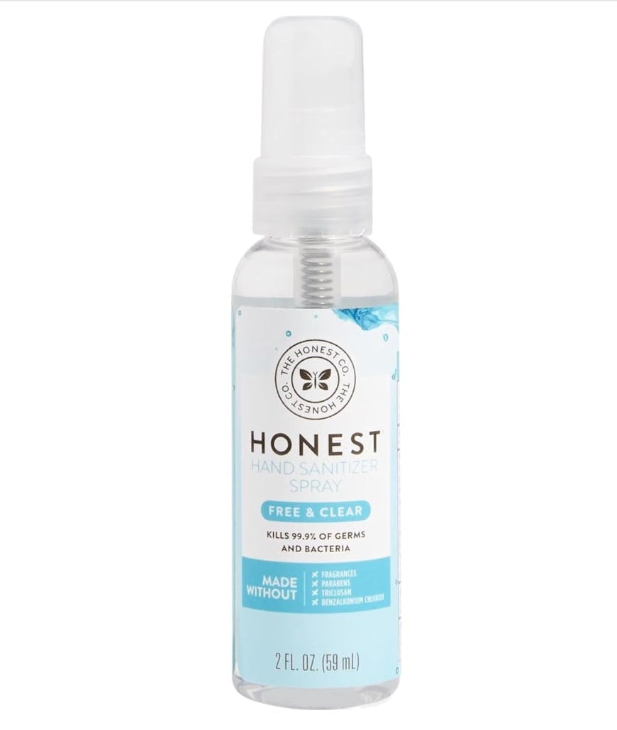 The Honest Company Free & Clear hand sanitizer spray bottle with clear cap and blue label on a white background.
