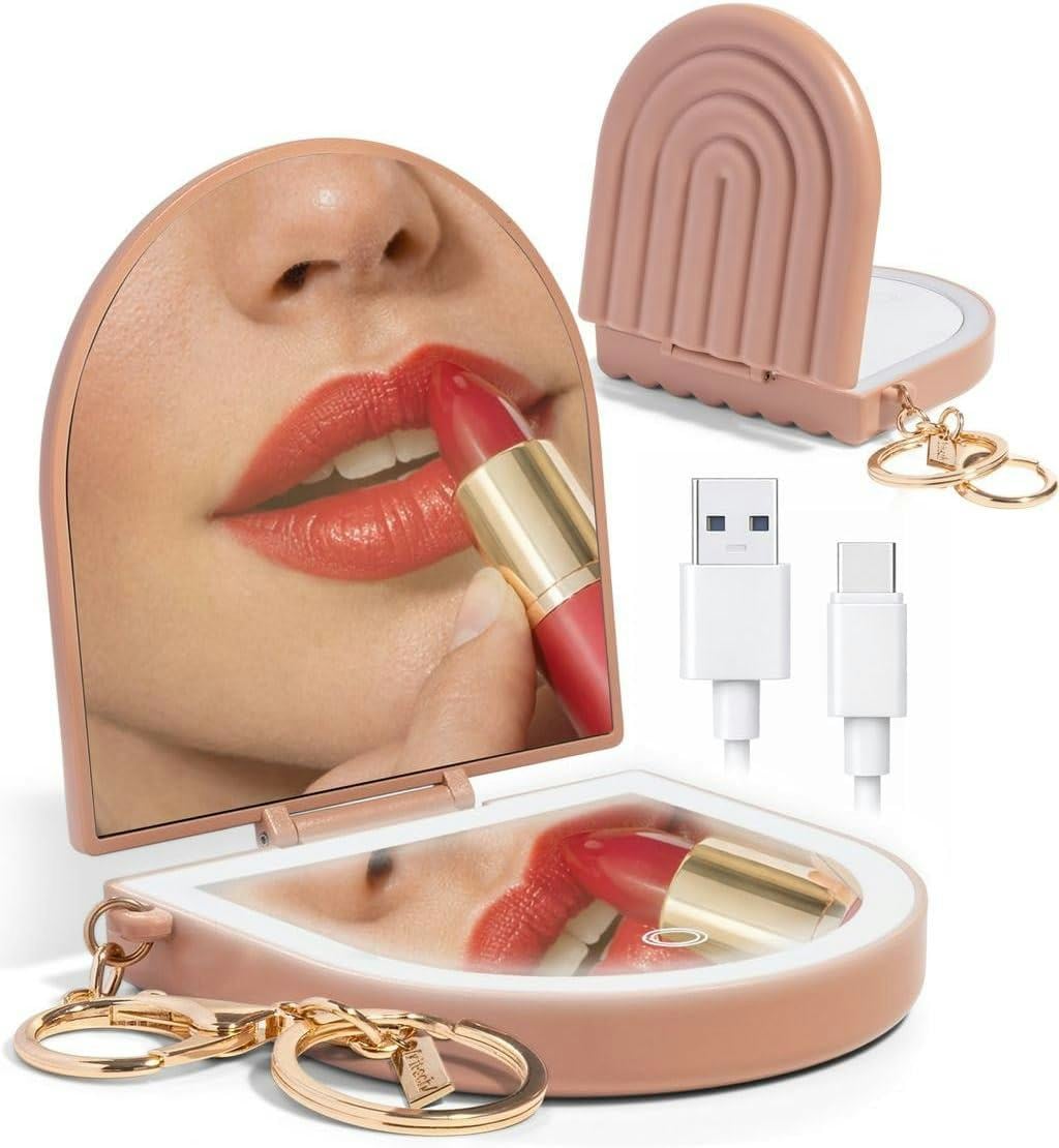 Pink keychain compact mirror with LED light, USB charging cable, and lipstick reflection for makeup touch-ups on the go