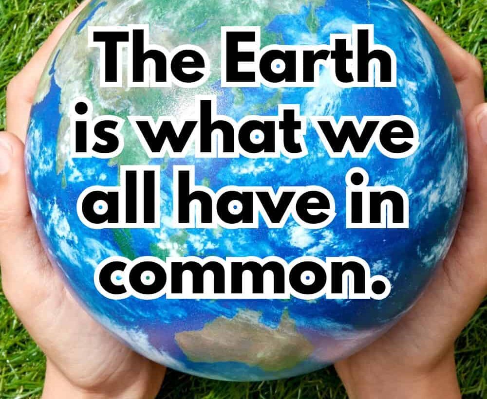 Hands hold an Earth globe on grass with the text 'The Earth is what we all have in common.' - Wendell Berry