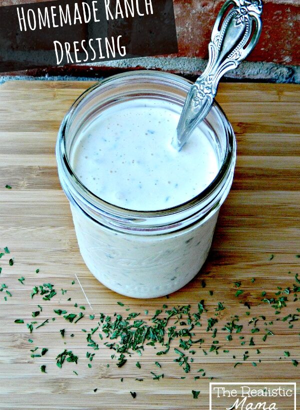 Jar of creamy dressing with a spoon on a cutting board, with herbs scattered around and title text above.