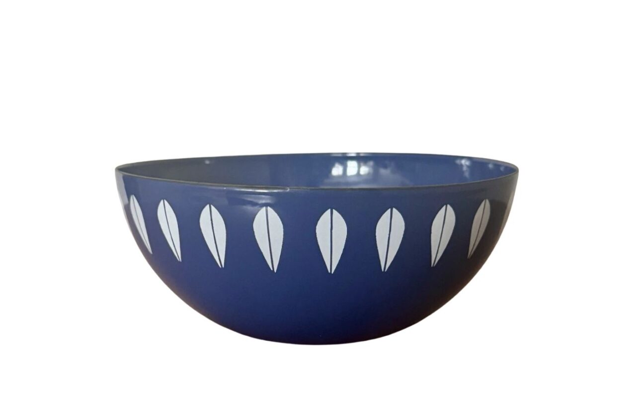 Blue bowl with white leaf-shaped pattern on a plain white background