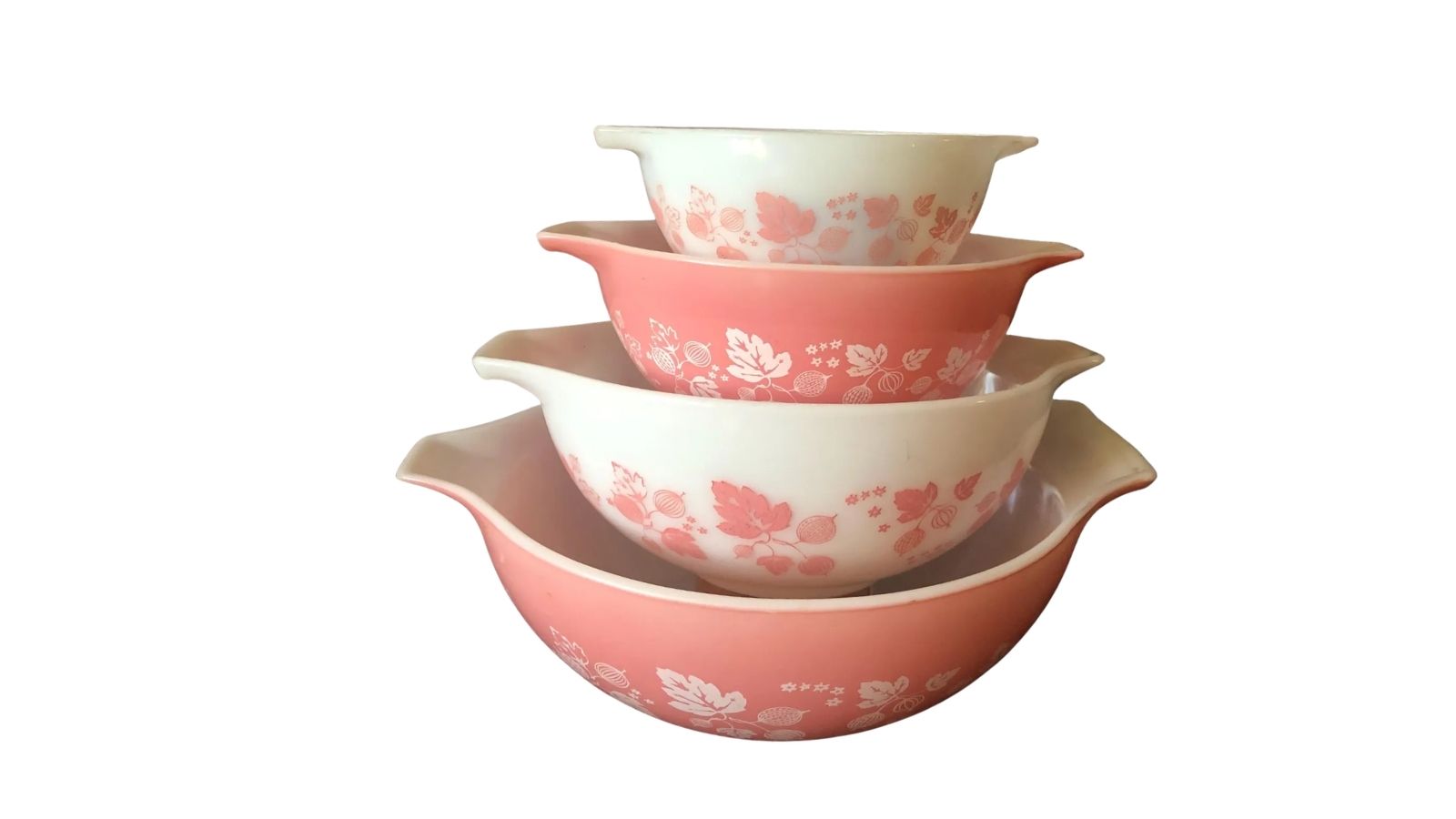 Stack of four pink and white floral nesting bowls on a plain white background