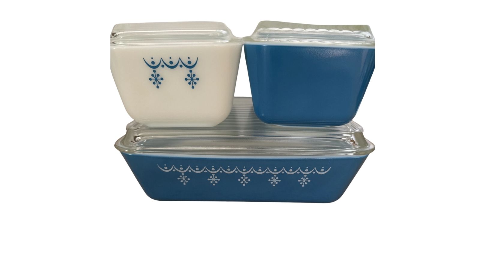 Blue and cream glass casserole dishes with clear lids and snowflake-style decorative patterns