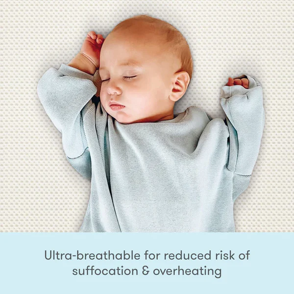 Sleeping baby in a pale outfit on a white textured surface with a blue text panel below