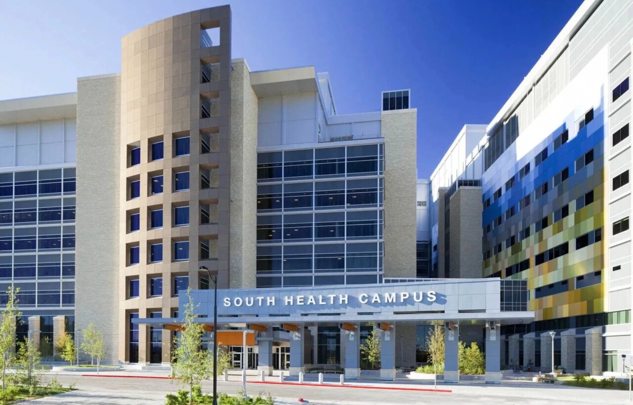 Modern multi-story building entrance with a sign reading South Health Campus.