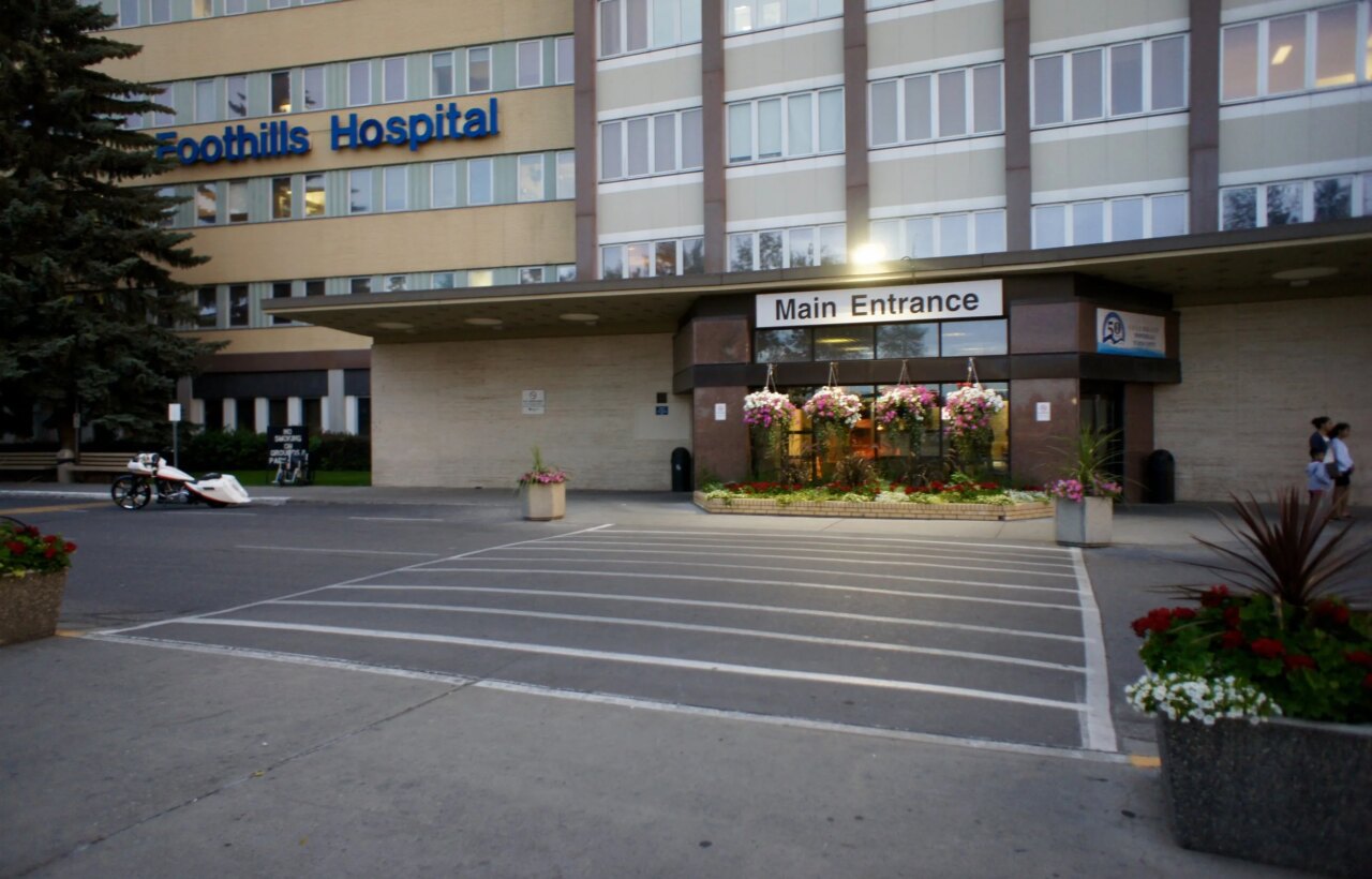 Foothills Hospital main entrance with flower planters and marked roadway in front