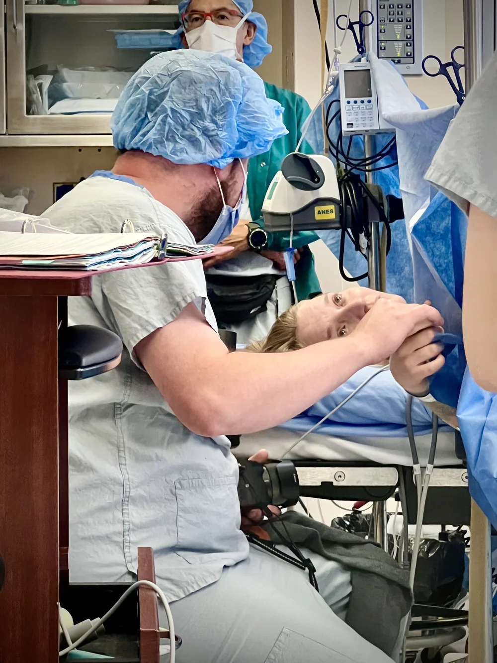 Person on a hospital bed with medical staff and equipment in an operating room