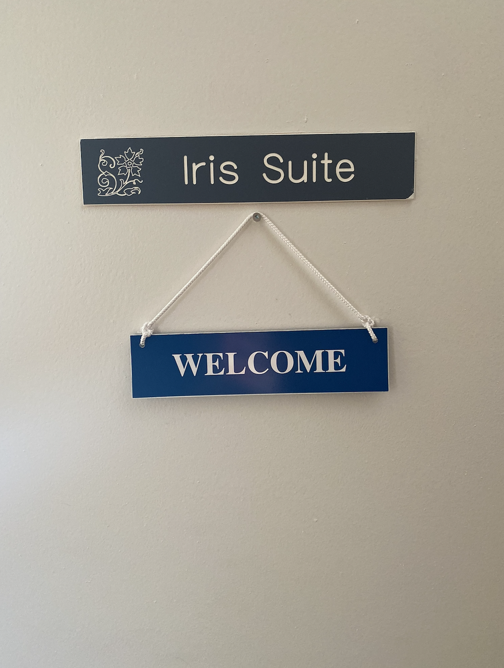 Door signs reading Iris Suite and WELCOME hanging on a beige wall