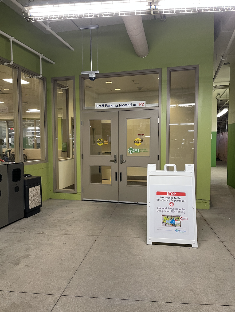 Green parking entrance doors with P1 signage and a stop sign for emergency department access
