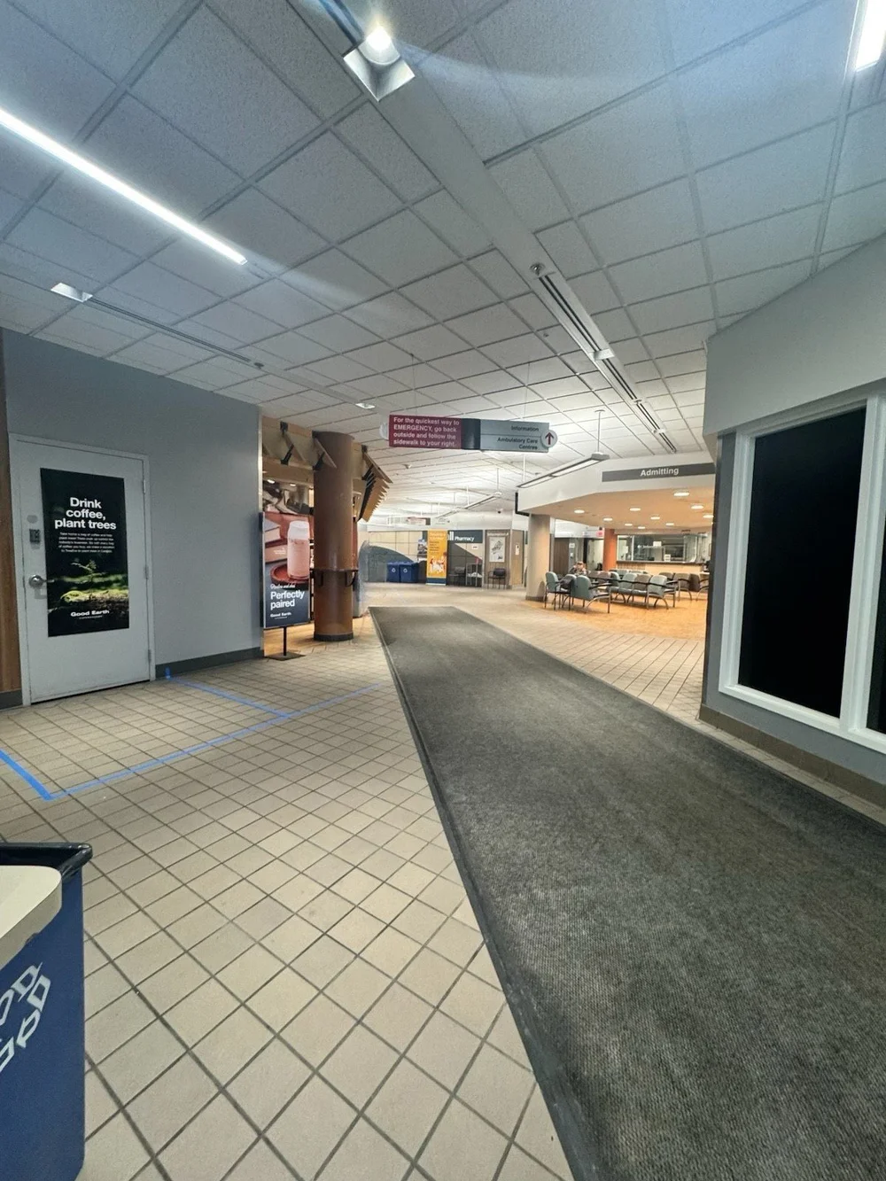 Hospital corridor with Admitting area, Pharmacy sign, seating, overhead wayfinding, and tiled floors