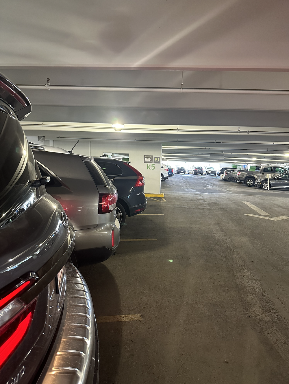 Indoor parking garage aisle with parked cars and a pillar marked K5 and P1