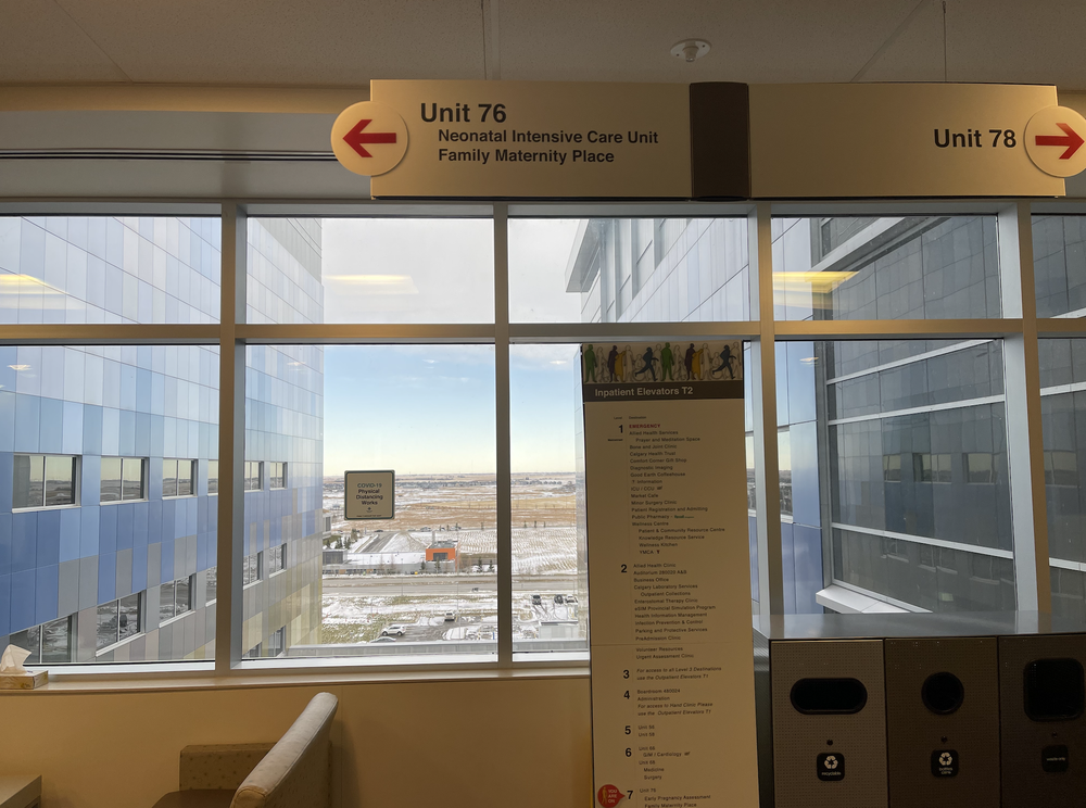 Hospital corridor signs point to Unit 76, Neonatal Intensive Care Unit and Family Maternity Place, and Unit 78.