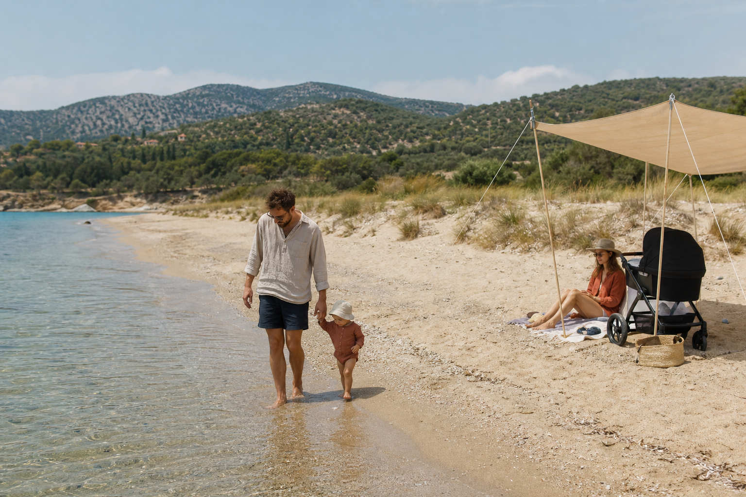 A parent walks with a toddler at the edge of a quiet Messinian beach while a baby rests in a shaded stroller nearby.